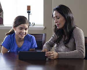 Woman and teen girl looking at electronic tablet.